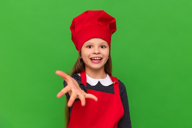 고립된 녹색 배경에 요리사 의상을 입은 귀여운 소녀