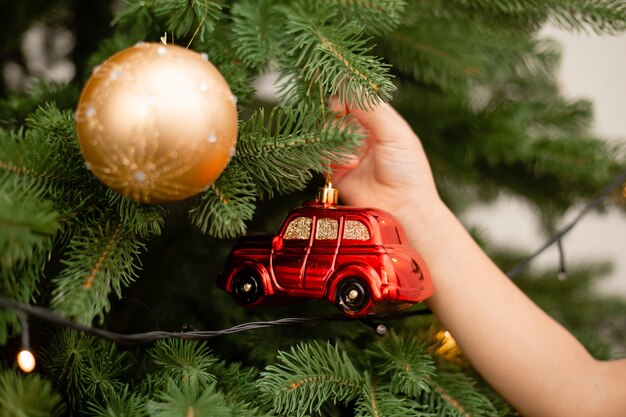 Photo cute little girl decorating christmas tree at home