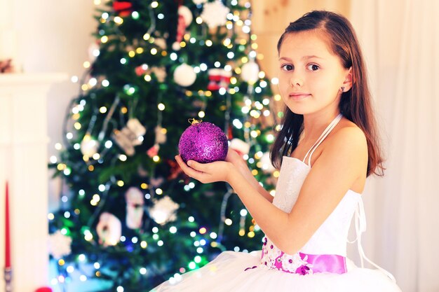 Cute little girl decorating Christmas tree