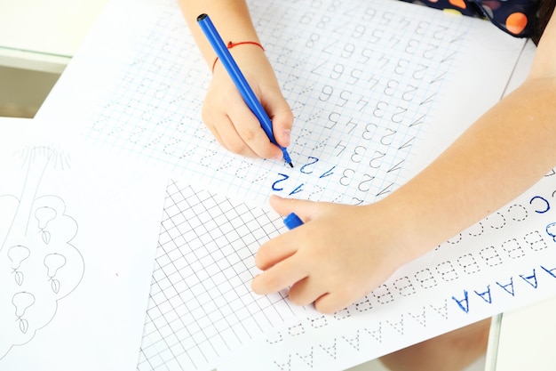 Cute little girl doing her homework closeup