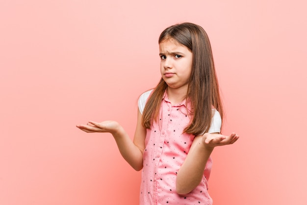 Photo cute little girl doubting between two options.