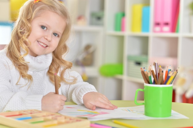 Cute little girl drawing in her room