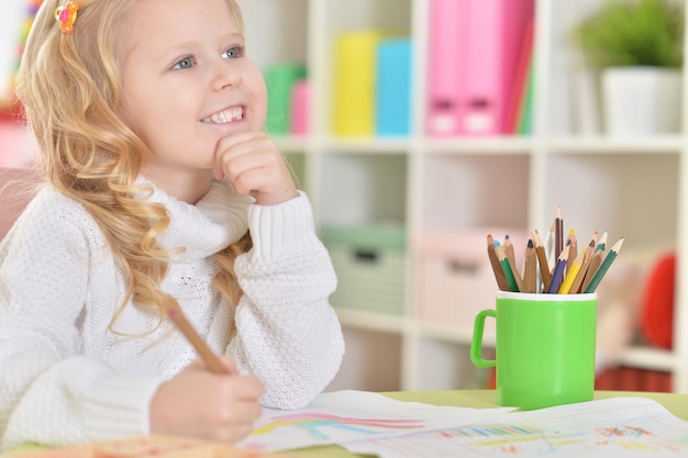 Cute little girl drawing in her room