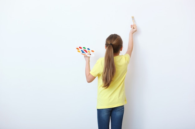 Cute little girl draws paints at home