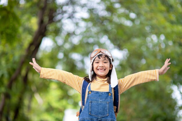 A cute little girl dressed in a cap and glasses of a pilot. The child dreams of becoming a pilot.