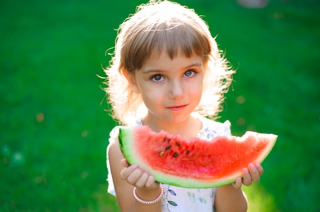 Cute little girl eating watermelon and enjoying picnic