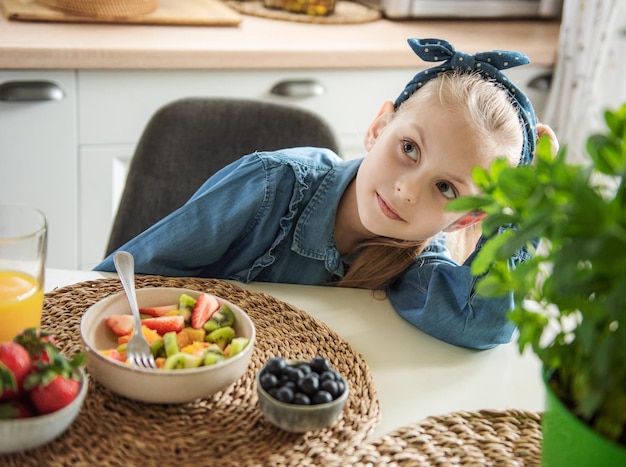 Cute little girl eats fruit salad