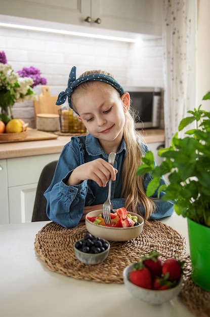 かわいい女の子はフルーツサラダを食べる