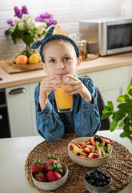 Cute little girl eats fruit salad