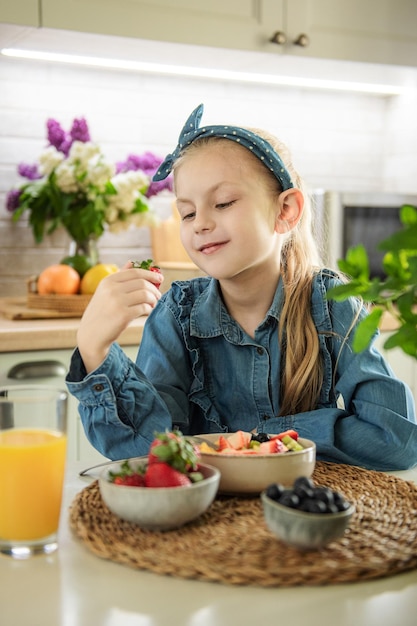 Cute little girl eats fruit salad