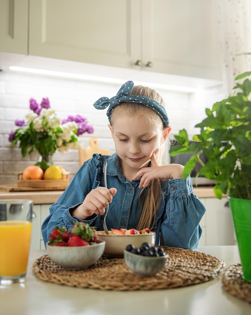 かわいい女の子はフルーツサラダを食べる