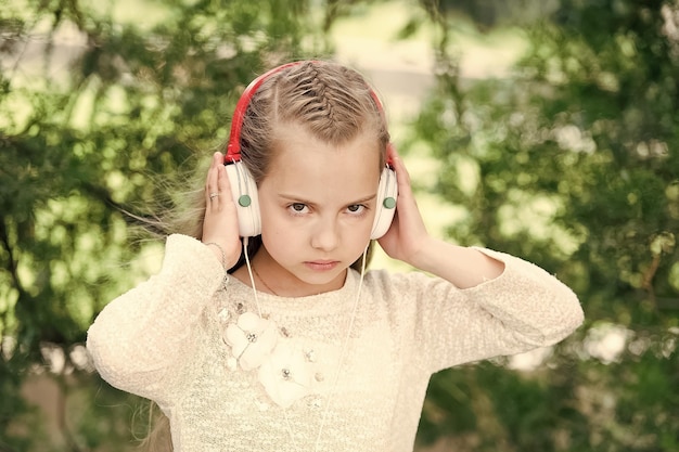 Cute little girl enjoying music using headphones