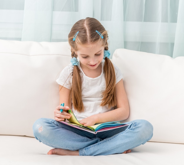 Cute little girl filling in a friends album