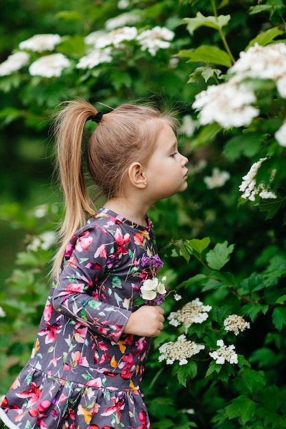 Photo cute little girl in a flower garden