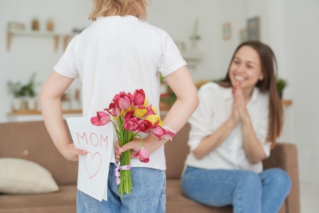 A cute little girl gives her mother a greeting card for mother's day or March 8