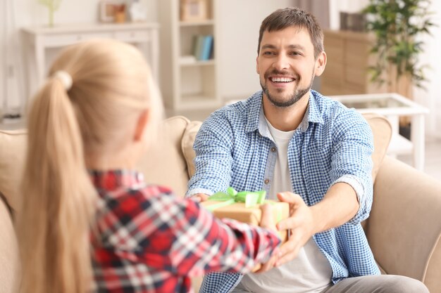 Bambina sveglia che saluta il suo papà con la festa del papà a casa