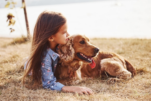 La bambina carina fa una passeggiata con il suo cane all'aperto in una giornata di sole