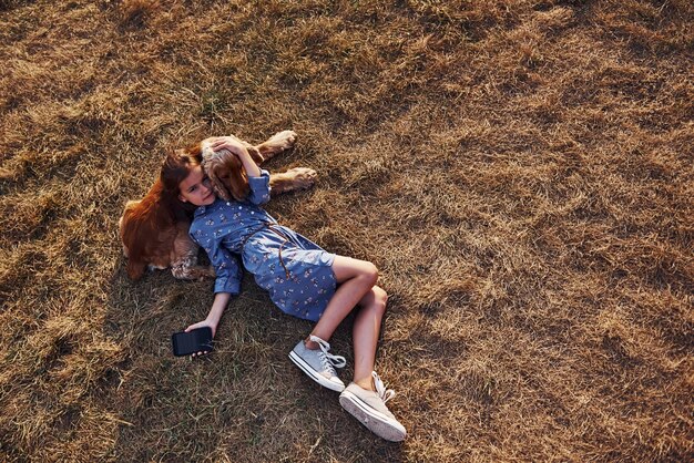 Cute little girl have a walk with her dog outdoors at sunny day