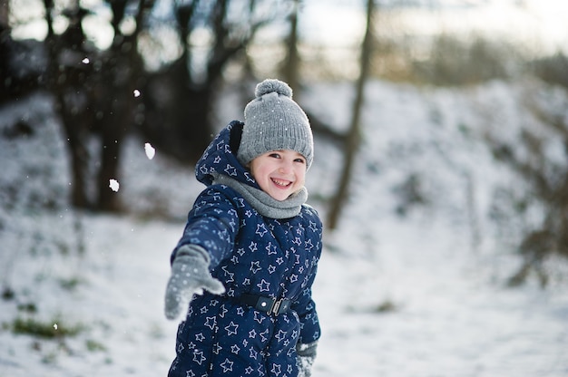 Милая маленькая девочка весело на открытом воздухе в зимний день.