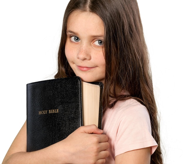 Cute little girl holding Bible on  background