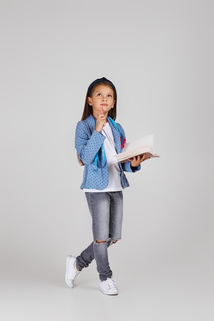 Cute little girl holding tape measure and notebook