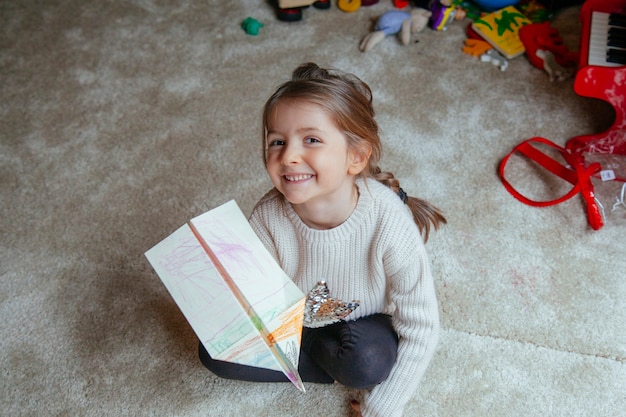 Photo cute little girl at home playing with happiness