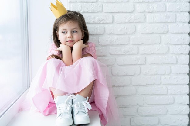 Фото Милая маленькая девочка в костюме принцессы красивый ребенок готовится к костюмированной вечеринке красивая королева в золотой короне