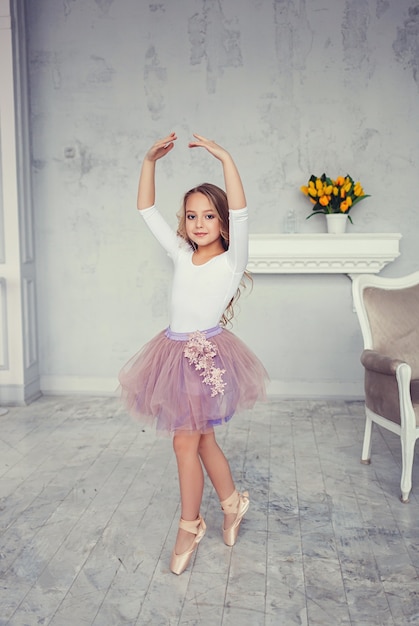 A cute little girl is dancing like a ballerina