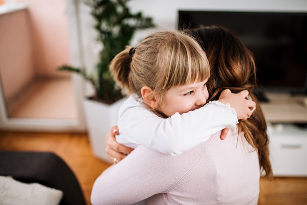 Cute little girl is hugging her mother.