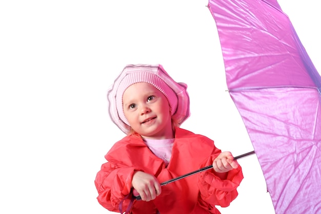 귀여운 소녀가 손에 분홍색 우산을 들고 서 있다
