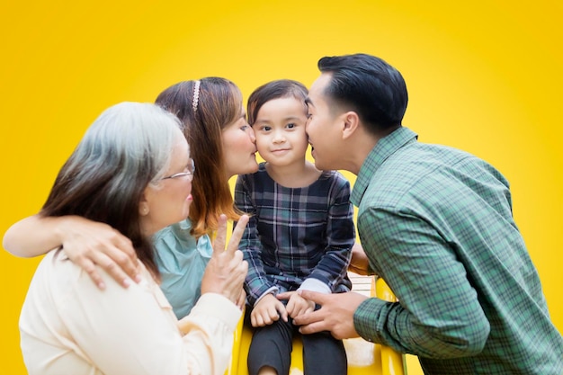 Cute little girl kissed by her family on the slide