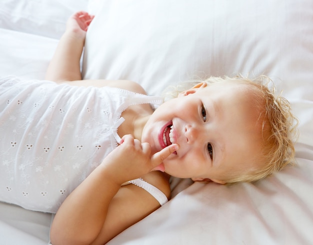 Cute little girl laughing in bed