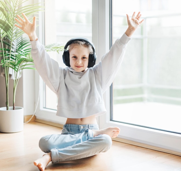 Photo cute little girl listening to music in headphones