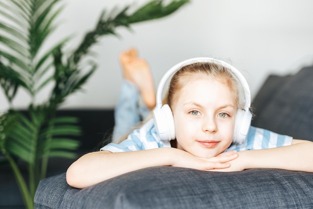 Cute little girl listening to music in headphones