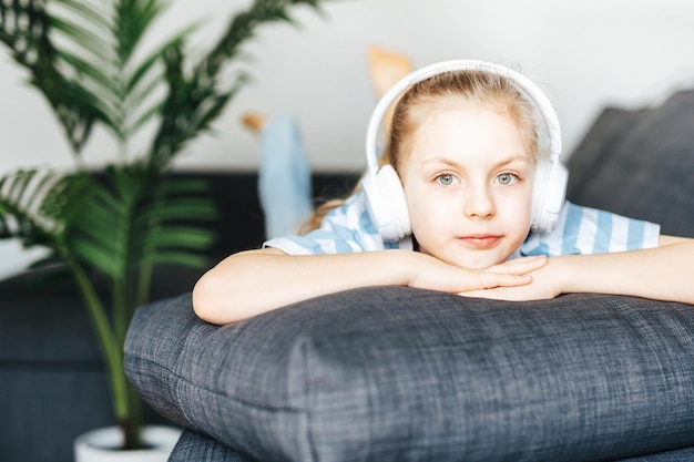 Cute little girl listening to music in headphones