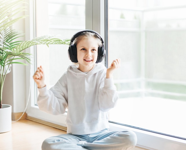 Cute little girl listening to music in headphones