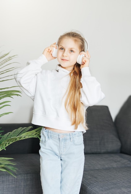 Cute little girl listening to music in headphones