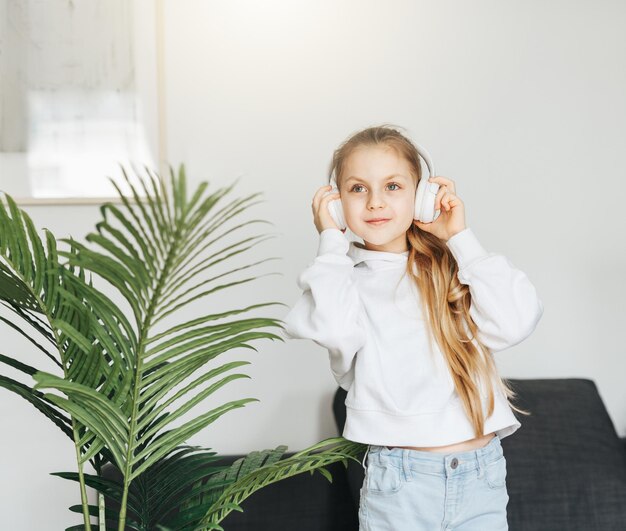 Cute little girl listening to music in headphones