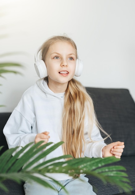 Cute little girl listening to music in headphones