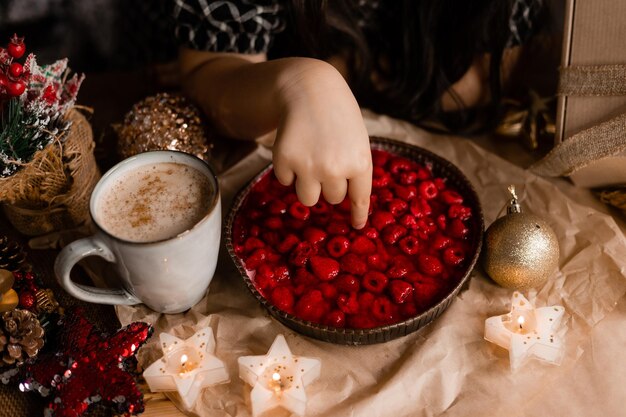 cute little girl made homemade raspberry pie in the kitchen at home for Christmas