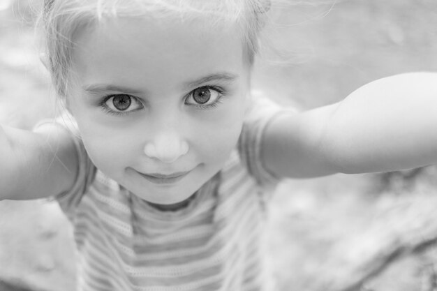 Cute little girl making selfie, black and white photo