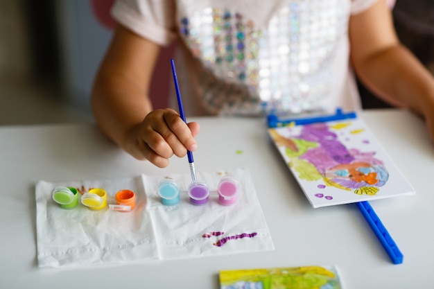 Immagine sveglia della pittura della bambina a casa.