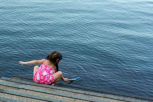 Bambina sveglia che gioca nel lago