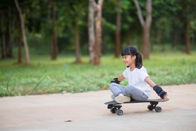 Cute little girl playing skateboard or surf skate in the skate park