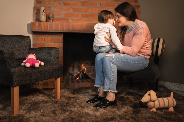 Cute little girl playing while sitting on her mother's lap.