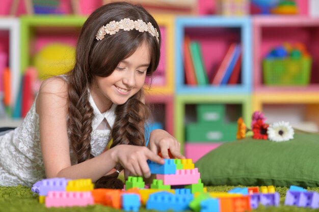 Cute little girl playing with colorful blocks