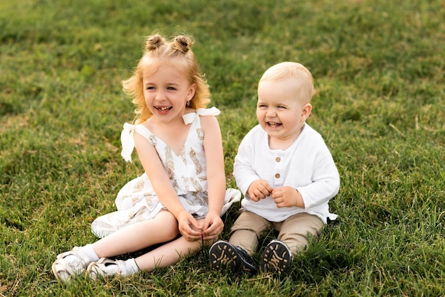 Cute little girl playing with her brother outside on a sunny day