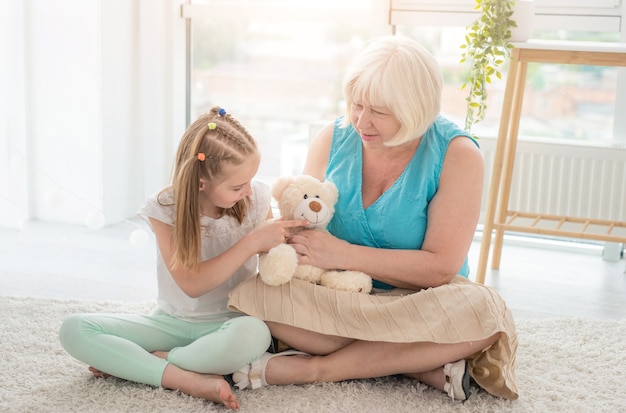 Cute little girl playing with mature woman