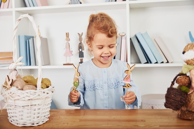 Cute little girl playing with toys when celebrating Easter holidays indoors