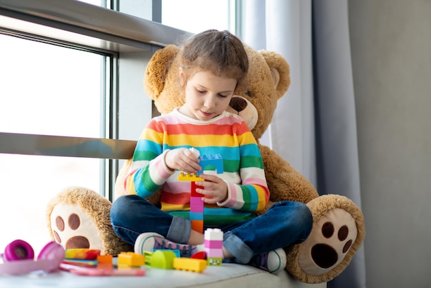 A cute little girl plays construction set Childhood Development